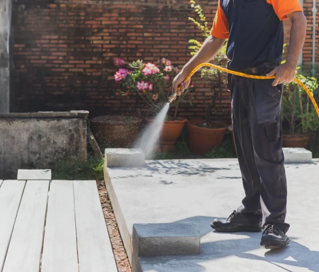 Expert pest control services technician spraying treatment in backyard