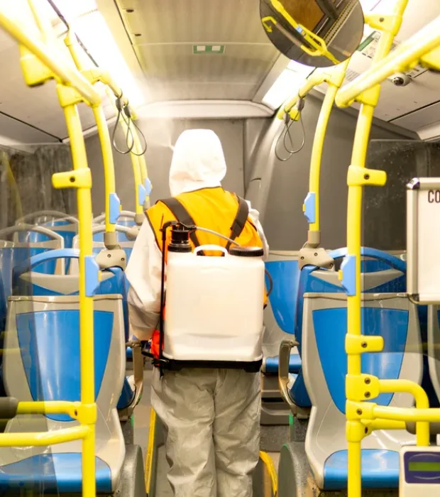 Inside a Melbourne bus, a professional with Transport Pest Solutions applies pest control measures for public safety.
